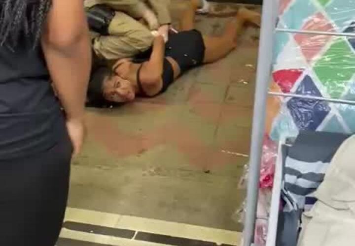 Mulher com criança no colo é imobilizada pela PM em Itabira - Foto: Reprodução/Redes Sociais