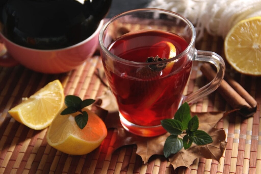 7 chás com limão para ajudar a desinchar 2 Xícara de vidro com chá de limão com hibisco e canela