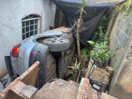 Carro com mulher e criança despenca em barranco e cai entre casas em Sabará - Foto: Divulgação/CBMMG